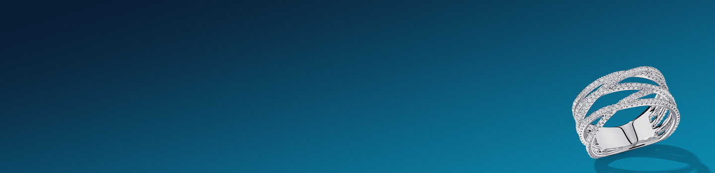 Bague Birks Ros&eacute;e du Matin en or blanc &agrave; diamant sur un fond bleu fonc&eacute;.